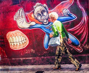  Energetic woman by superhero mural illustrating Duality Hack 1: Every experience is make-believe