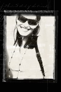 Black and white portrait photo of a smiling woman wearing oversized sunglasses