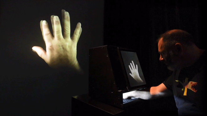 Animation graphic of a man putting his hand inside a box with the box shown on a screen as if his fingers grow longer and shorter