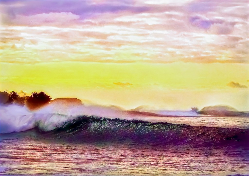 Colourful big rolling ocean waves creating small short lived bubbles on top of the water