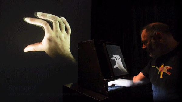 Animation graphic of a man putting his hand inside a box, with fingers moving in impossible ways on a digital screen