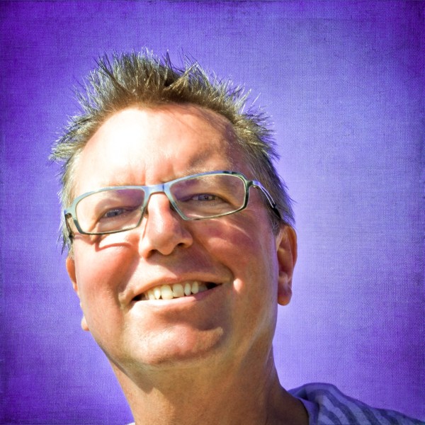 Alexius Jorgensen smiling with a white halo against a deep violet sky background