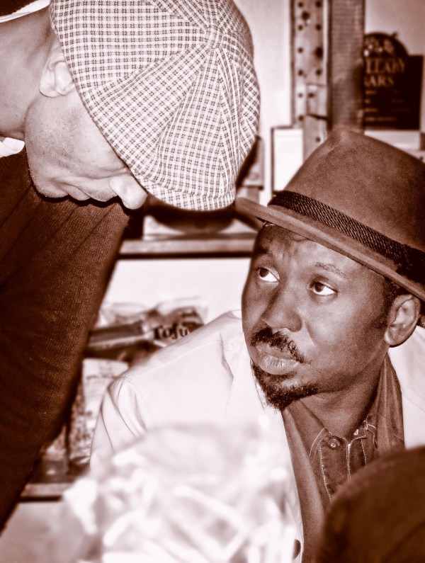 Sepia photo of a white man and a black man talking in a friendly manner representing opposites