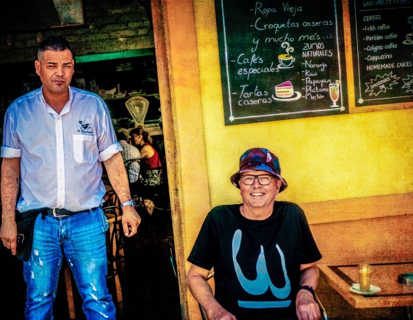 Alexius Jorgensen relaxing and drinking a coffee in a Canarian restaurant alongside a waiter