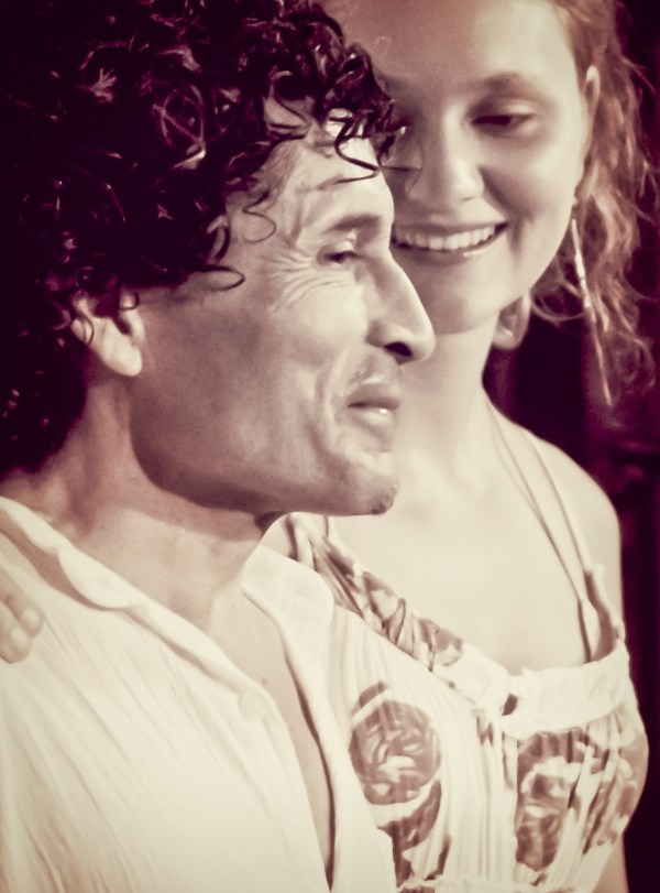 A mature male musician and a smiling young female musician posing together