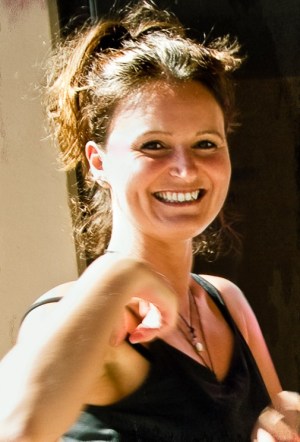 Woman with a very big smile gesticulating while playing by the rules of the duality game