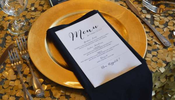 Menu card resting on a white dinner plate illustrating experiences as mere symbols