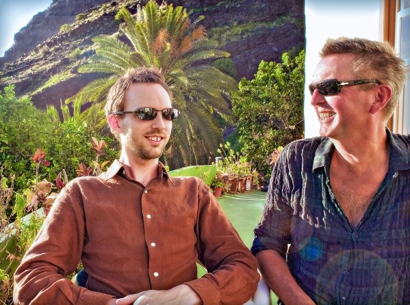 Alexius Jorgensen and his son sitting together on his outdoor terrace with palm trees